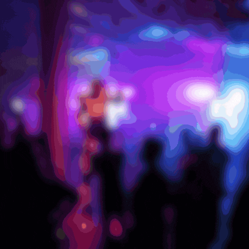 a blurry picture of a crowd of people at a concert with purple and blue lights