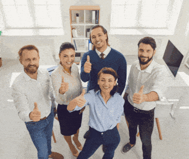 a group of people giving a thumbs up in an office