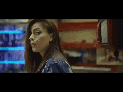 a woman with a bandage on her mouth is standing in front of a vending machine