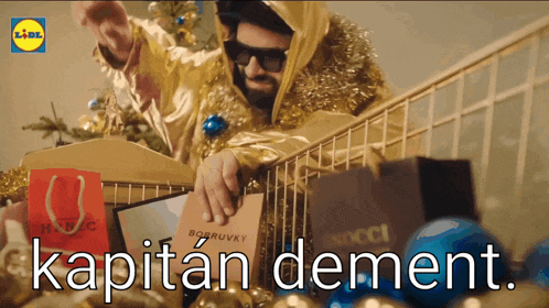 a man in a gold outfit is pushing a cart full of shopping bags with the words kaptan dement written in white