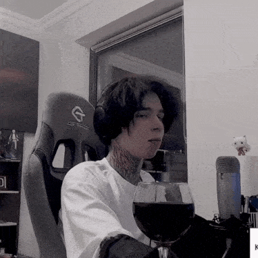 a man with a tattoo on his neck is sitting in a gtracing chair