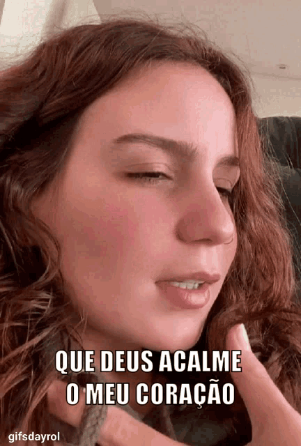 a close up of a woman 's face with the words que deus acalme o meu coracao above her