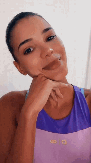 a woman wearing a purple tank top that says 00
