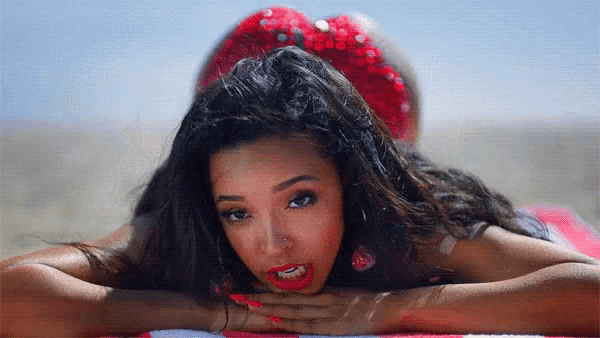 a woman laying on a towel with her head on her hands