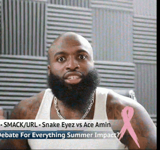 a man with a beard is wearing a white tank top and has a pink ribbon on his shoulder