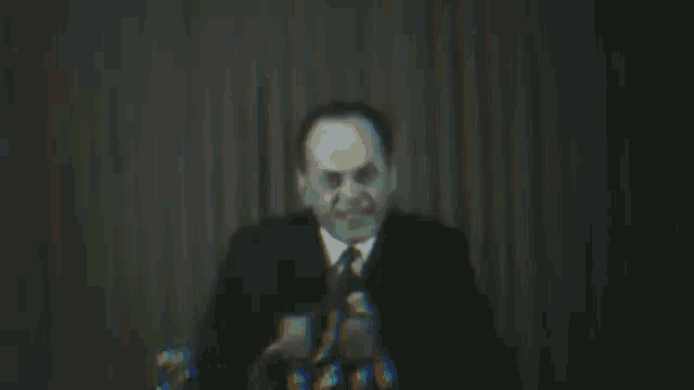 a man in a suit and tie is giving a speech at a podium .