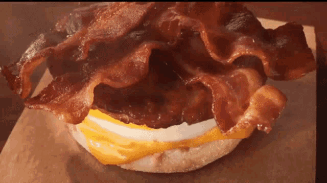 a close up of a sandwich with bacon and eggs