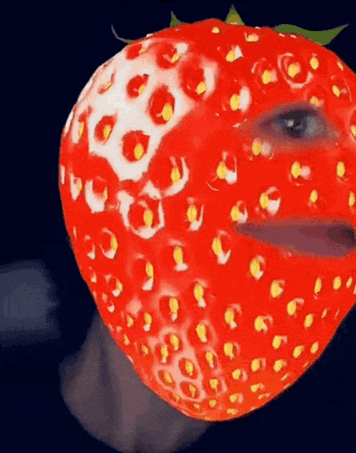 a close up of a strawberry with a person 's face painted on it