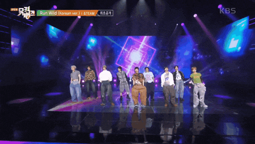 a group of people standing on a stage with the kbs logo in the corner