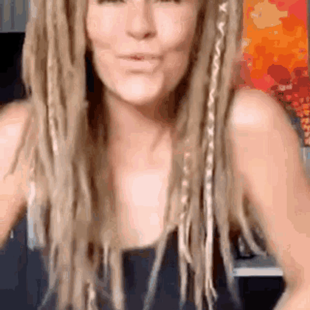 a woman with dreadlocks is making a funny face .