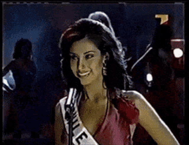 a woman is wearing a sash that says e on it