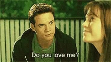 a man and a woman are talking to each other and the man is asking the woman if she loves him .