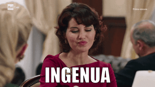 a woman in a red dress is sitting at a table with the word ingenia written on the screen