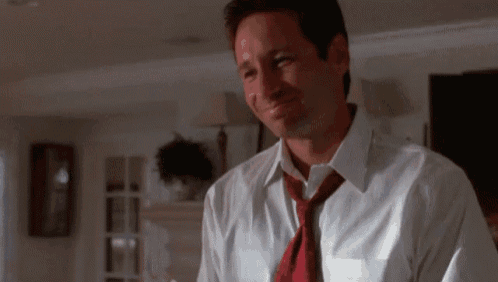 a man wearing a white shirt and a red tie is smiling .
