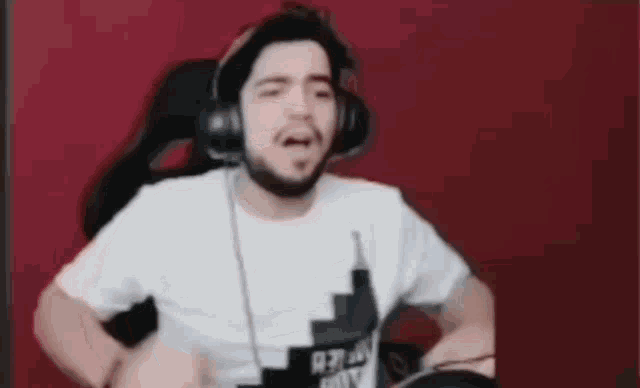 a man wearing headphones and a white shirt is dancing .
