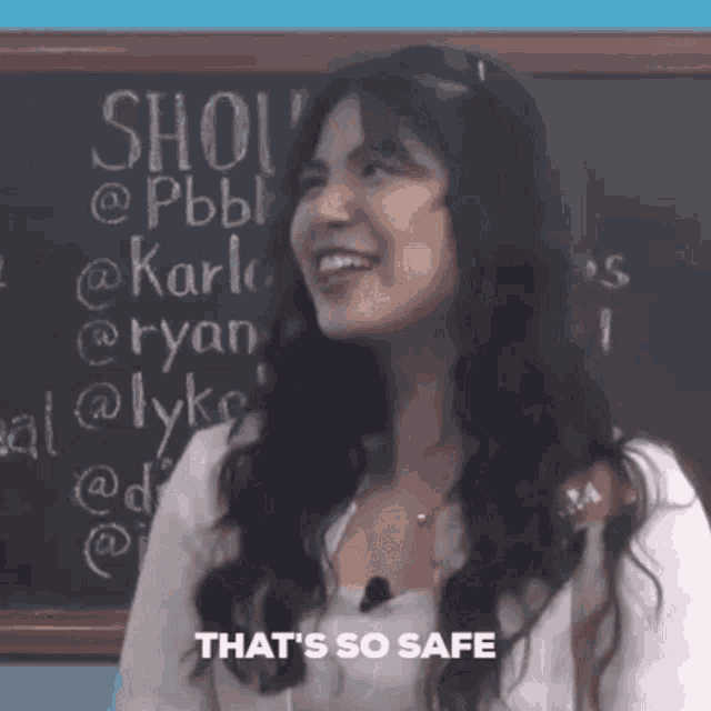 a woman stands in front of a blackboard that says show