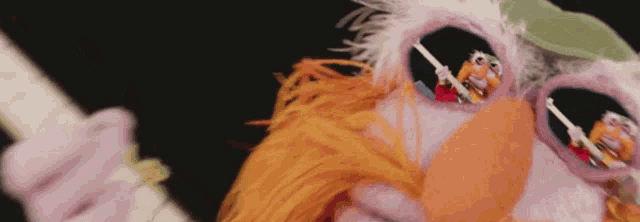 a close up of a muppet wearing sunglasses and a hat