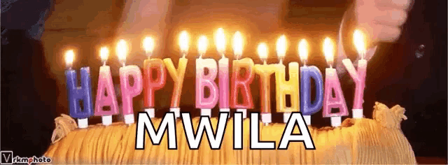a birthday cake with lit candles that say happy birthday mwla