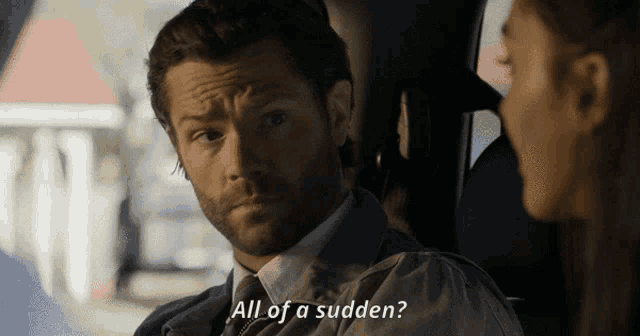 a man in a suit and tie says " all of a sudden " to a woman