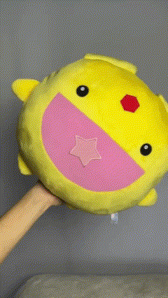 a person is holding a yellow stuffed animal with a pink star on it