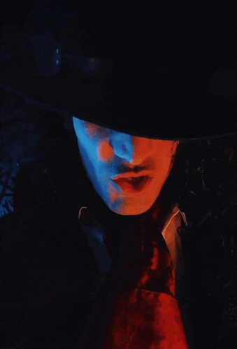 a close up of a person 's face with a hat and tie
