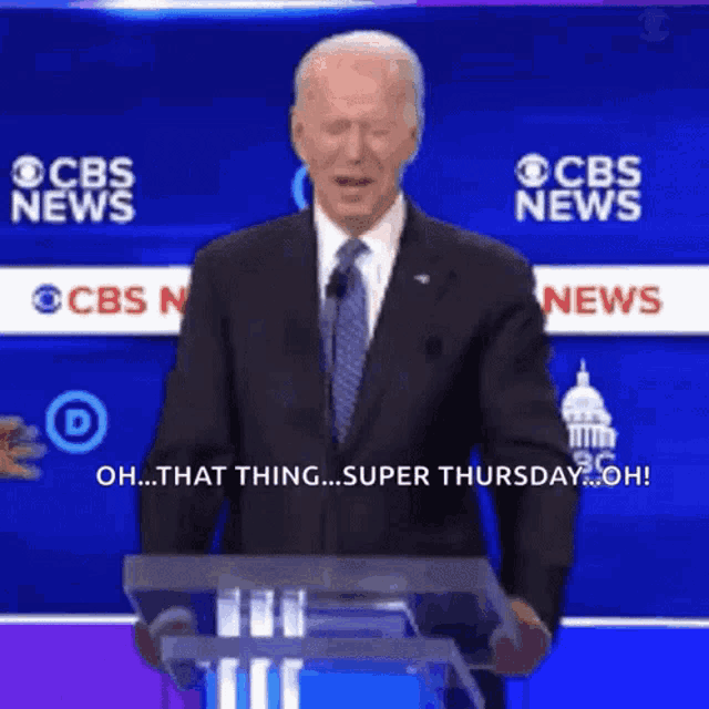 a man in a suit and tie stands behind a podium with cbs news behind him