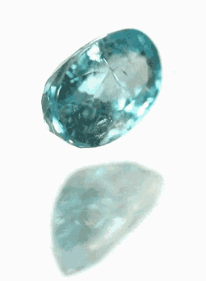a blue stone is laying on a white surface with a reflection