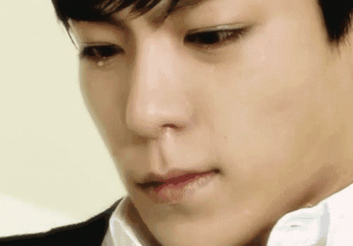 a close up of a young man 's face with a tear coming out of his nose .