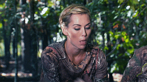 a woman wearing a camo shirt sticks out her tongue