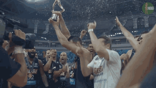 a group of basketball players are celebrating with a trophy and the word nba on the bottom right