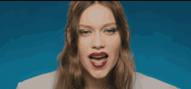 a close up of a woman 's face with red lipstick and blue eyeshadow