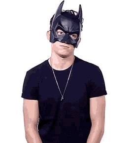 a man wearing a black shirt and a batman mask .