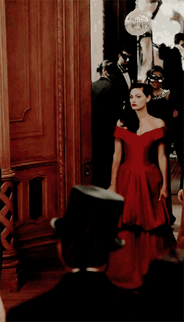 a woman in a red dress is standing next to a man in a black top hat