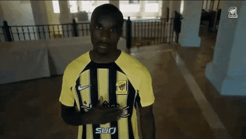 a man wearing a yellow and black shirt that says surj