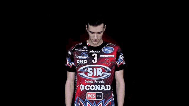 a man wearing a red shirt with the number 3 on it stands with his arms crossed
