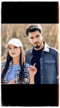 a man and a woman are posing for a picture and the woman is wearing a hat