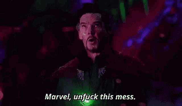 doctor strange is standing in a dark room with a green light in his hand .