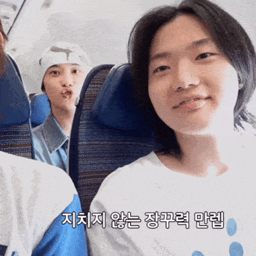 a couple of people sitting on a plane with korean writing