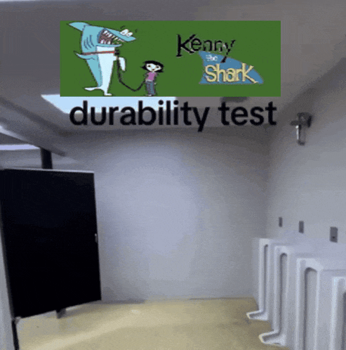 a bathroom with urinals and a kenny the shark poster on the wall