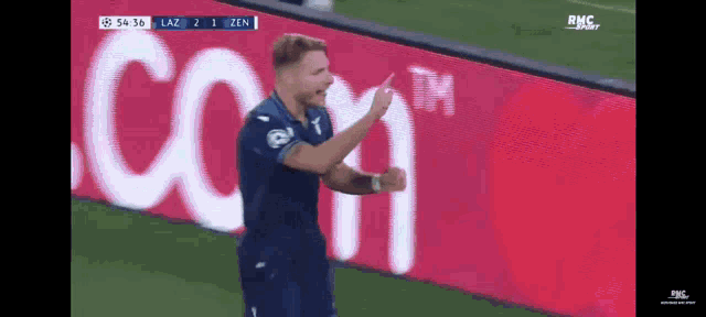 a soccer player celebrates a goal in front of a sign that says rms