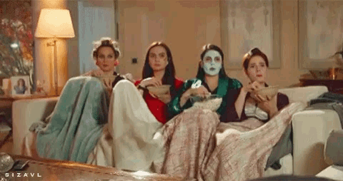 a group of women are sitting on a couch and one has a mask on her face ..