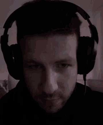 a man wearing headphones is looking at the camera .