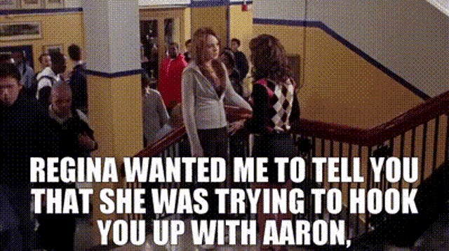 a woman is standing on a staircase talking to another woman .
