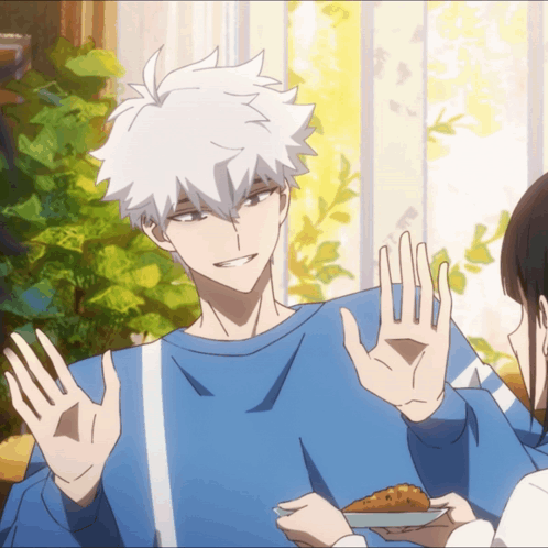 a man in a blue sweater is giving a peace sign