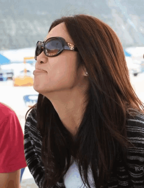a woman wearing sunglasses with a prada logo on the lens