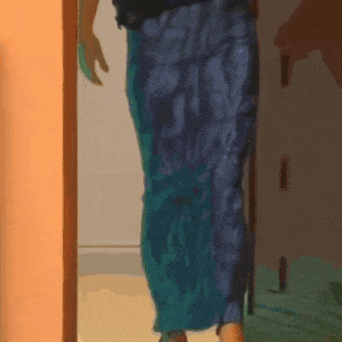 a woman in a blue skirt is standing in a room