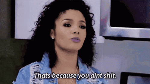 a woman in a denim jacket is standing in a kitchen and saying that 's because you ain t shit .