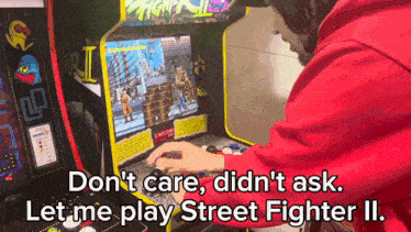 a person is playing street fighter ii on a video game machine
