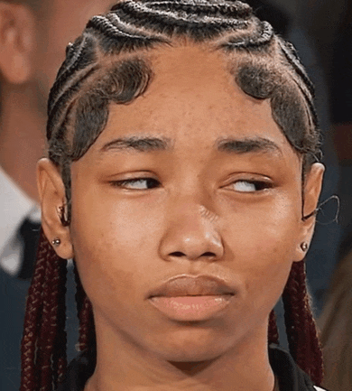 a close up of a girl 's face with braids