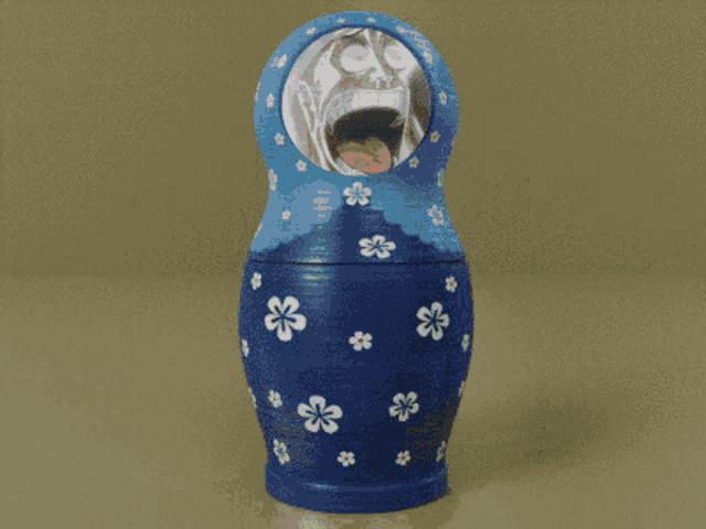 a blue green and orange russian nesting doll with a child 's face on it